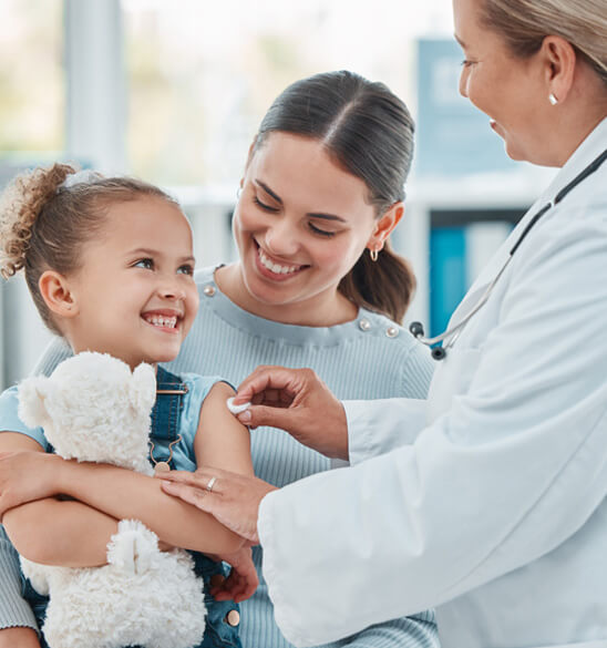 family practice doctor wiping a vaccination area on little girl's arm