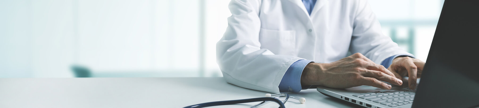 Hands of a doctor in Newark, NJ, typing on a computer.