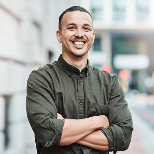 man smiling with arms crossed