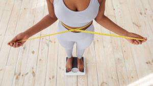 woman measuring her waist after weight loss