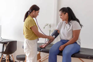 primary care doctor measuring patient's blood pressure