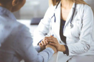 primary care doctor holding patient's hand