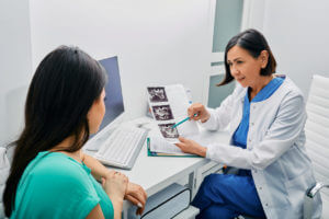 An adult woman is consulting with her gynecologist about her exam results and ultrasound of her ovaries at a Women's Primary Care center.
