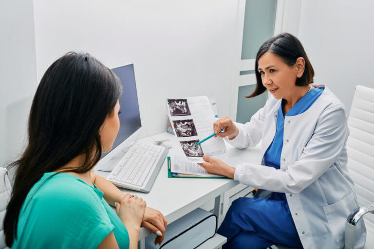 An adult woman is consulting with her gynecologist about her exam results and ultrasound of her ovaries at a Women's Primary Care center.