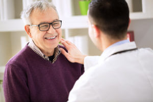 A smiling, happy senior patient visits their primary care doctor.