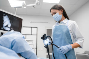 A female doctor is holding a modern endoscope device in preparation for a gastroscopy examination and colonoscopy.