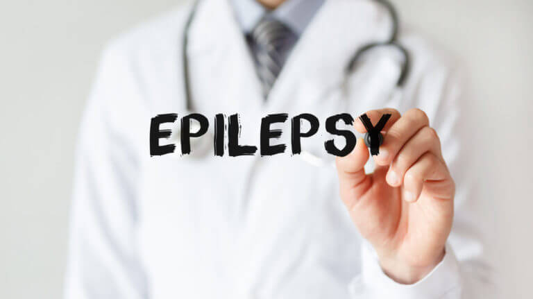 A neurologist writing word Epilepsy with marker.