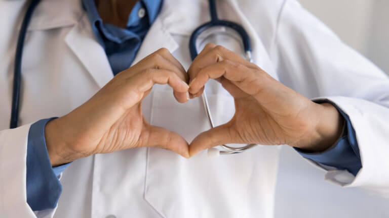 Close up cropped shot of a top cardiologist showing heart gesture.
