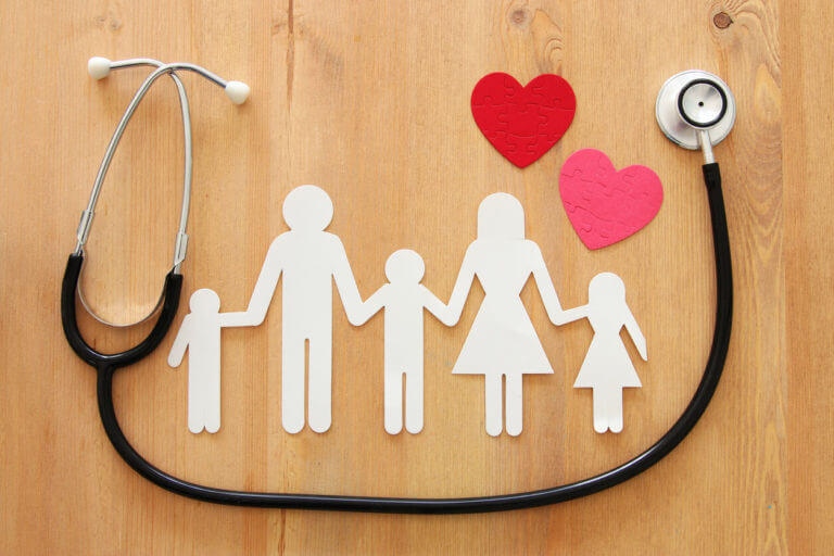 Family medicine concept using image of Stethoscope and family on wooden table.